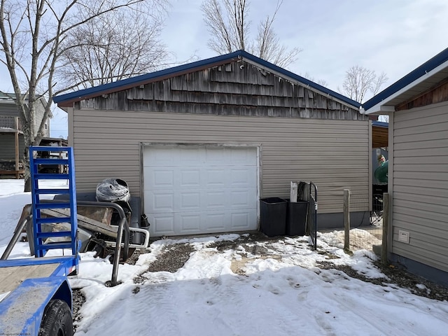 snow covered garage featuring a detached garage