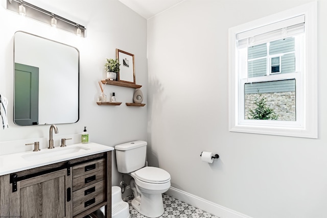 bathroom with a healthy amount of sunlight, toilet, and vanity