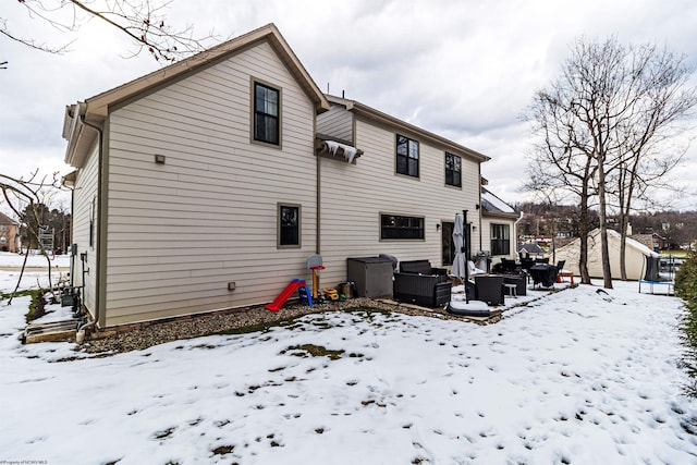 view of snow covered back of property