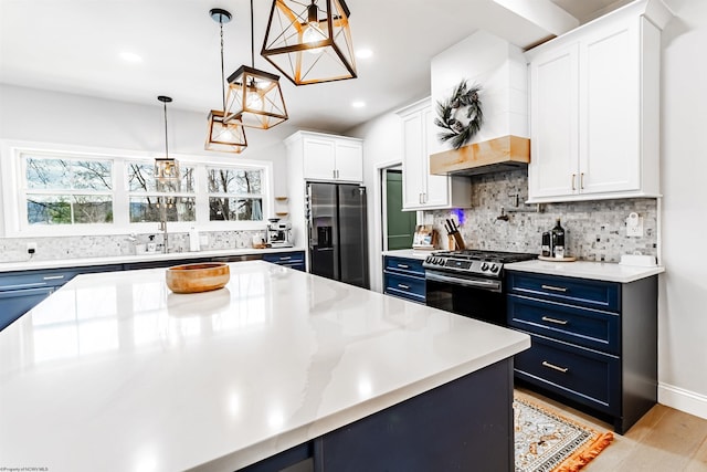 kitchen featuring pendant lighting, appliances with stainless steel finishes, white cabinetry, backsplash, and blue cabinets