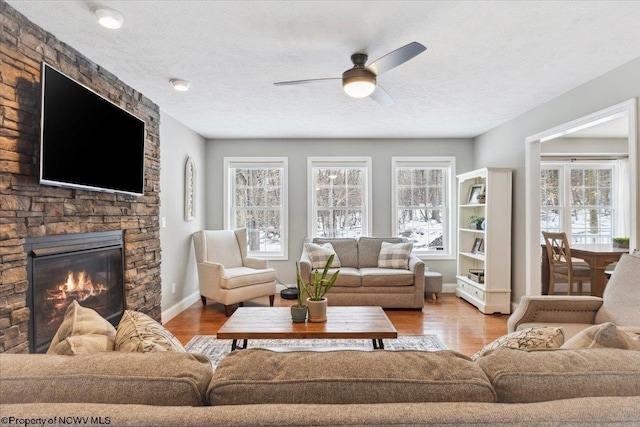 living room with a healthy amount of sunlight, a fireplace, hardwood / wood-style floors, and a textured ceiling