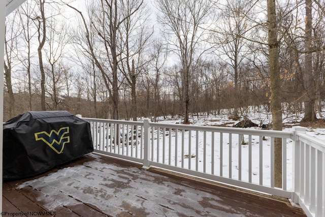 snow covered deck with a grill