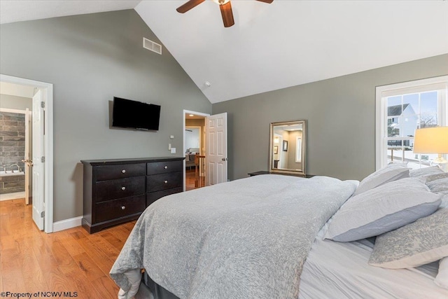 bedroom with high vaulted ceiling, light hardwood / wood-style floors, ceiling fan, and ensuite bathroom