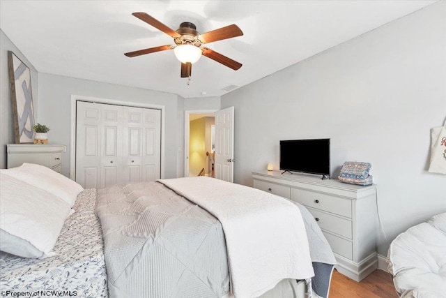 bedroom with ceiling fan, a closet, and light hardwood / wood-style flooring