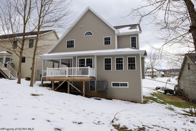 snow covered property with central AC