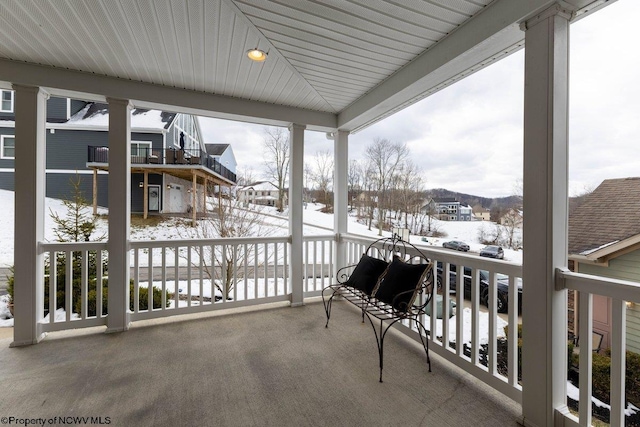 view of snow covered back of property