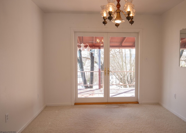 interior space with carpet flooring, a chandelier, and french doors