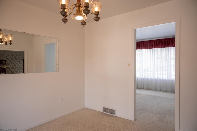 unfurnished room featuring a chandelier and carpet floors