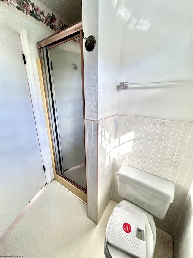 bathroom featuring toilet, tile walls, and walk in shower