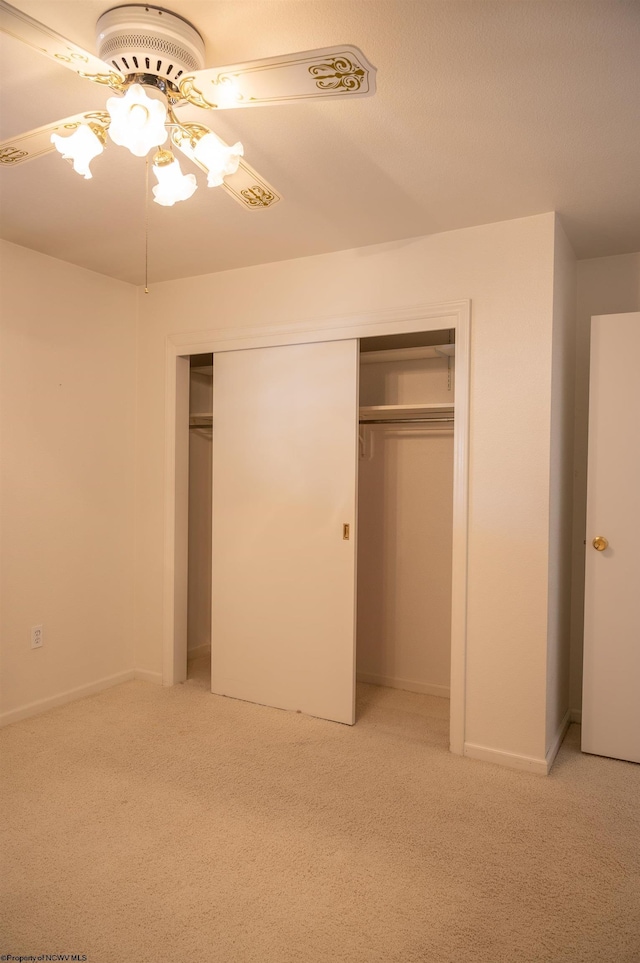 unfurnished bedroom featuring light carpet, ceiling fan, and a closet