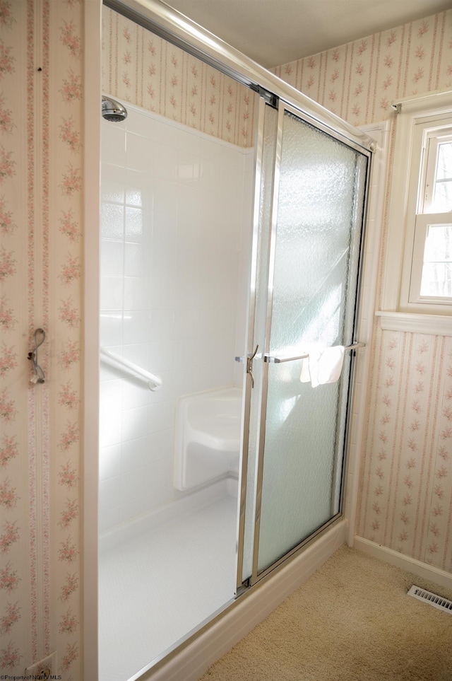 bathroom featuring a shower with door