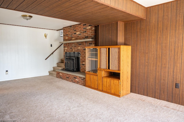 unfurnished living room with wooden walls, carpet floors, and wooden ceiling