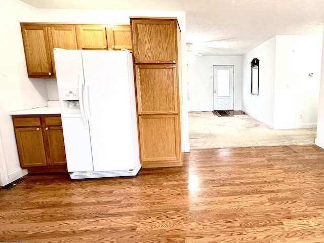 kitchen featuring white fridge with ice dispenser and light wood-type flooring