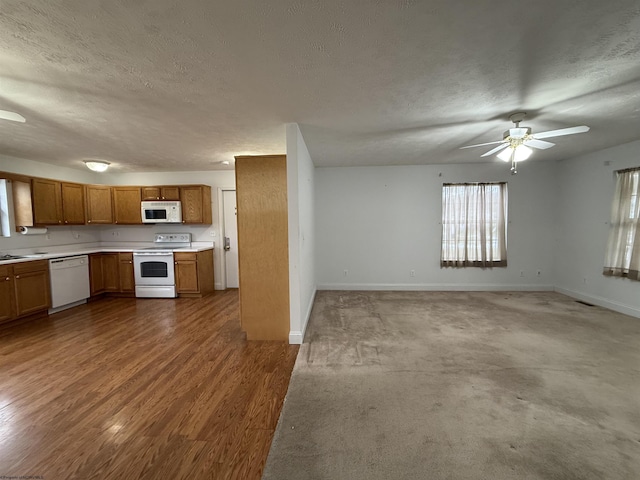 kitchen featuring dark wood-type flooring, white appliances, ceiling fan, and a textured ceiling