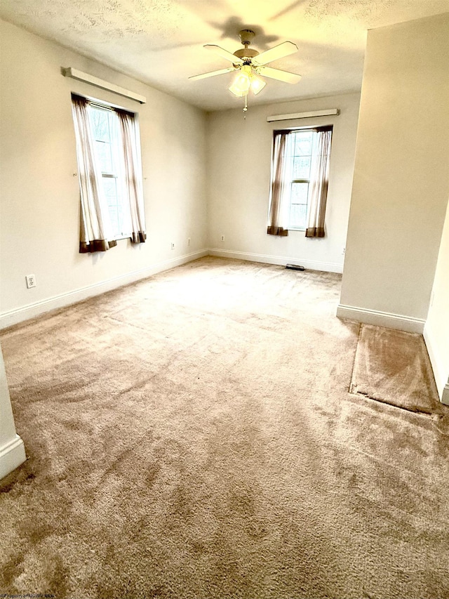 unfurnished room with ceiling fan, a textured ceiling, and carpet flooring