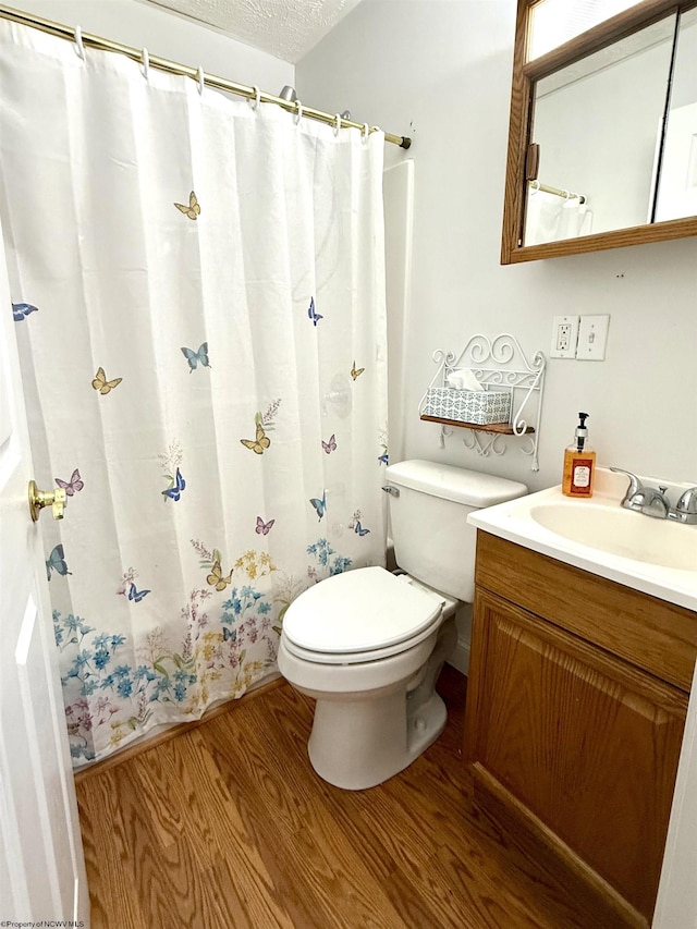 bathroom with vanity, hardwood / wood-style flooring, toilet, and a textured ceiling