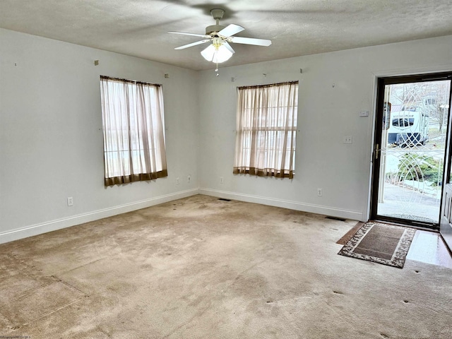 entrance foyer with light carpet, ceiling fan, and a textured ceiling