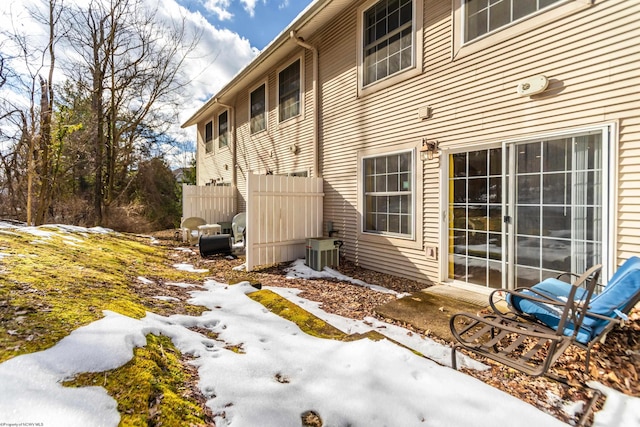 snow covered property with central AC