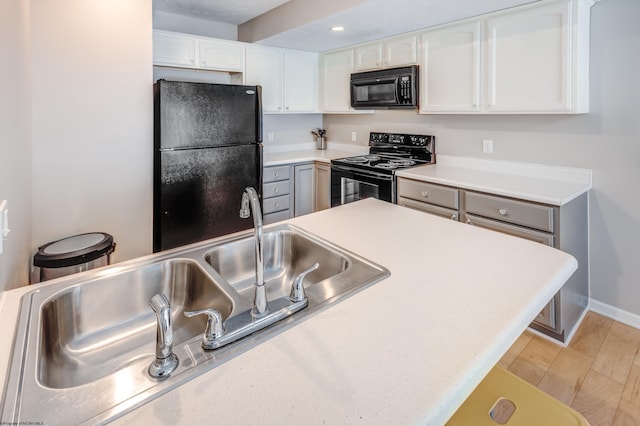 kitchen with white cabinetry, sink, light hardwood / wood-style flooring, and black appliances