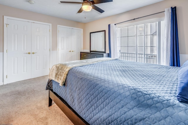 bedroom featuring multiple closets, carpet floors, and ceiling fan