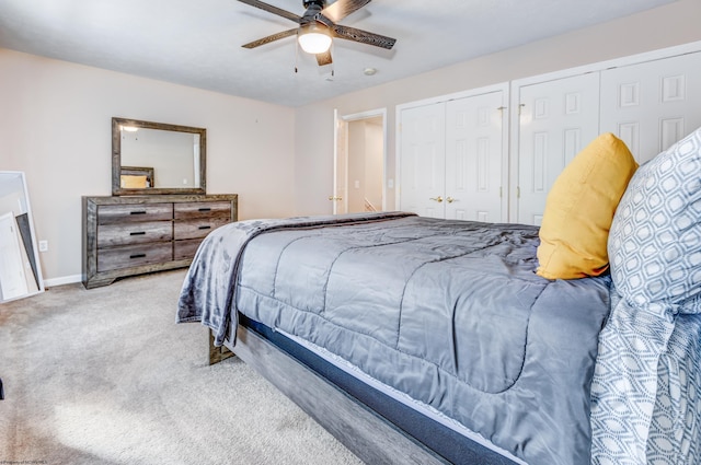 carpeted bedroom featuring ceiling fan and two closets