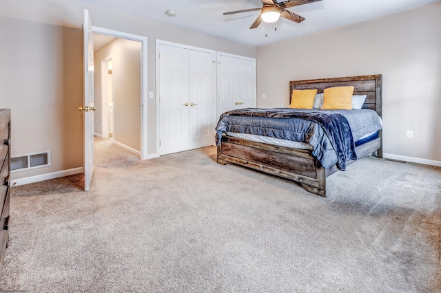 carpeted bedroom featuring two closets and ceiling fan