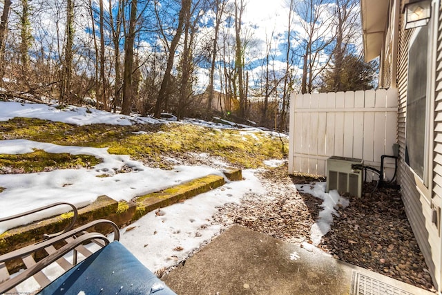 yard layered in snow featuring central air condition unit