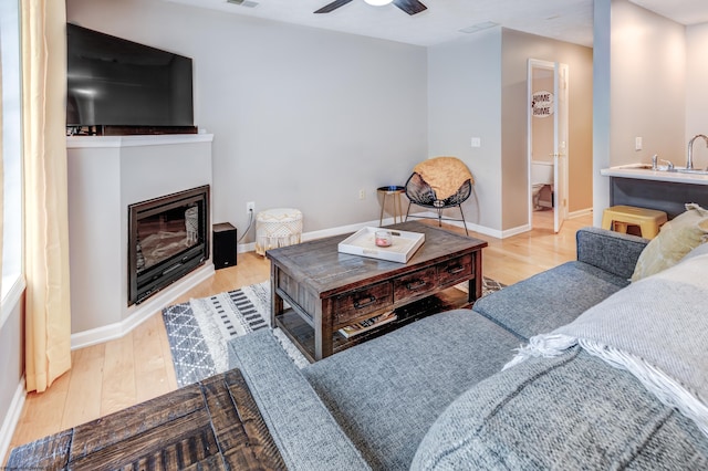 living room featuring ceiling fan and light hardwood / wood-style floors