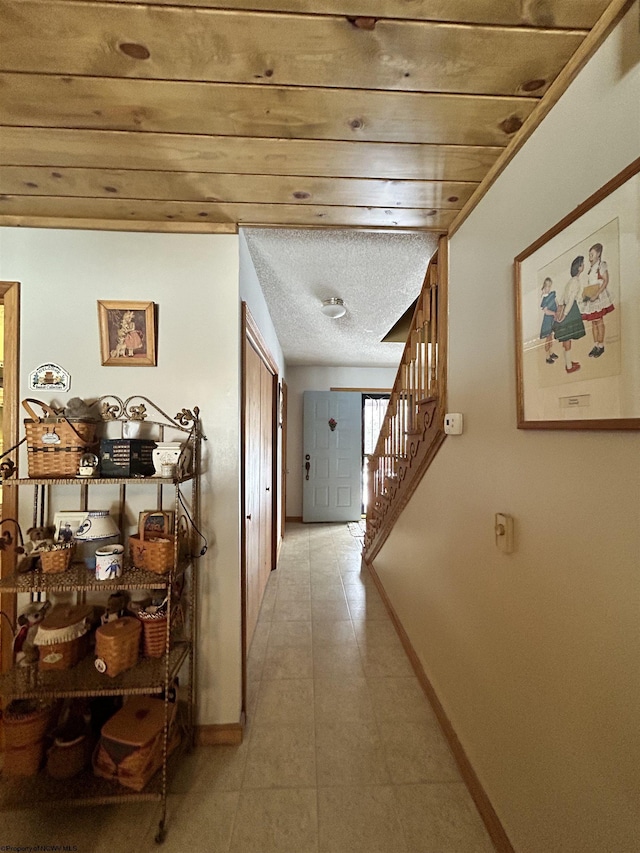 hallway with light tile patterned floors and a textured ceiling