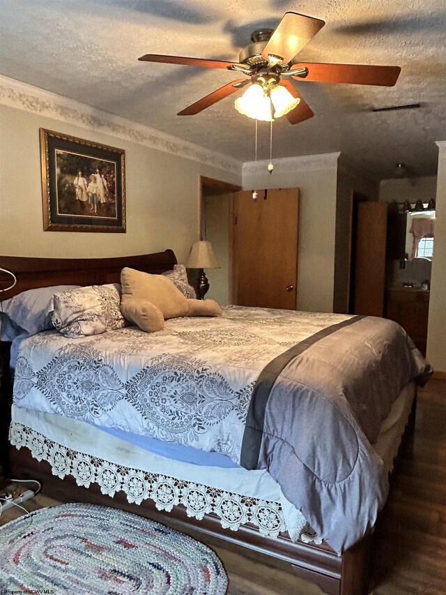 bedroom with hardwood / wood-style flooring, ceiling fan, ornamental molding, and a textured ceiling