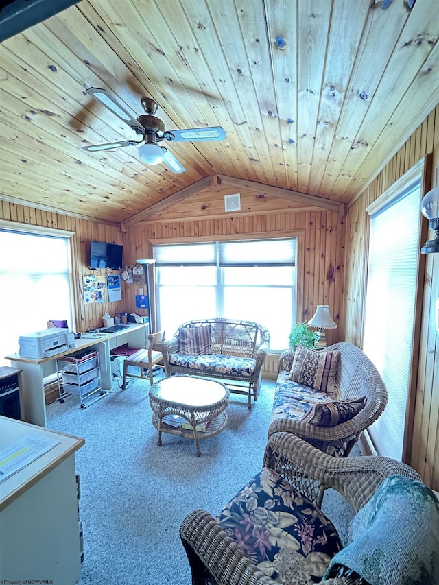 living room featuring a healthy amount of sunlight, lofted ceiling, carpet floors, and wooden walls