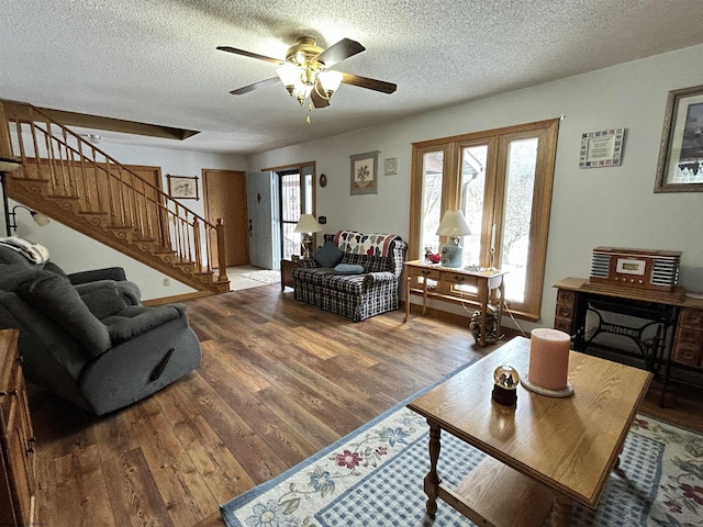 living room featuring hardwood / wood-style floors, a textured ceiling, and ceiling fan