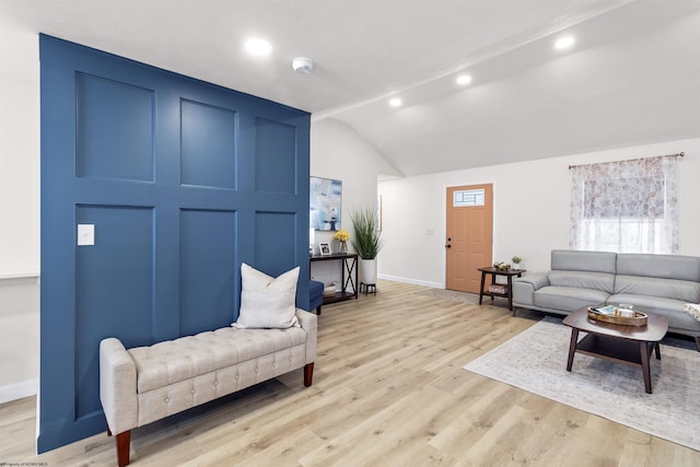 living room with light hardwood / wood-style floors and vaulted ceiling