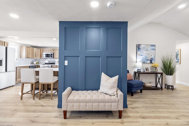 living area with lofted ceiling and light hardwood / wood-style flooring