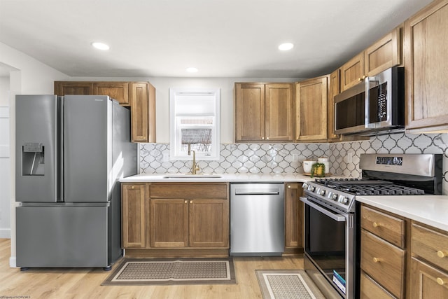 kitchen with sink, backsplash, stainless steel appliances, and light wood-type flooring