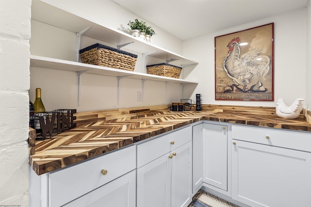 kitchen featuring white cabinetry and butcher block counters