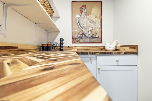 bar with wooden counters and white cabinets