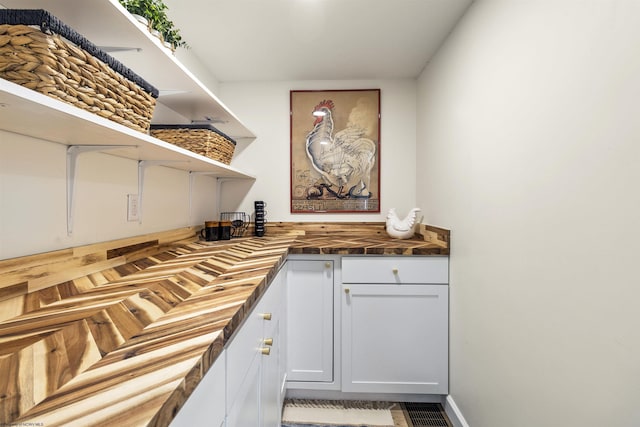 kitchen with white cabinetry and wooden counters