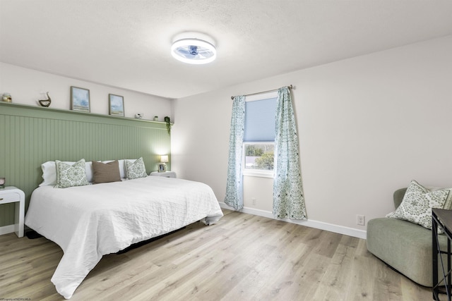 bedroom with light hardwood / wood-style flooring and a textured ceiling