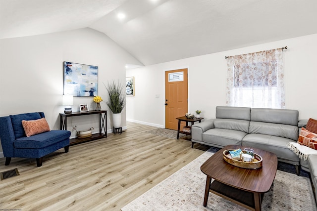 living room featuring light hardwood / wood-style flooring and vaulted ceiling