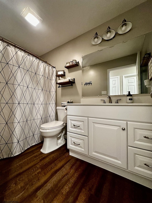 bathroom with vanity, wood-type flooring, and toilet