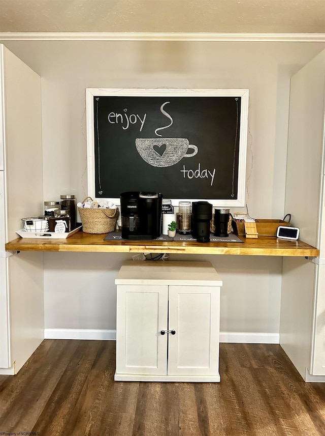 bar featuring dark wood-type flooring, wood counters, and white cabinets