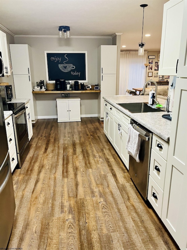 kitchen with appliances with stainless steel finishes, pendant lighting, white cabinetry, sink, and light stone counters