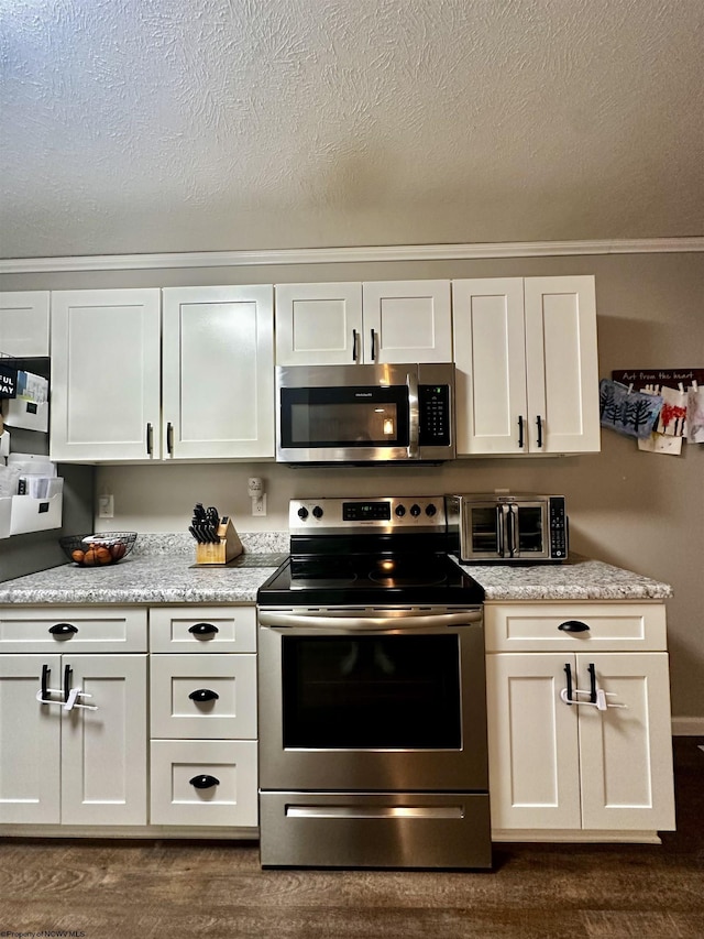 kitchen with stainless steel appliances, a textured ceiling, white cabinets, and dark hardwood / wood-style flooring