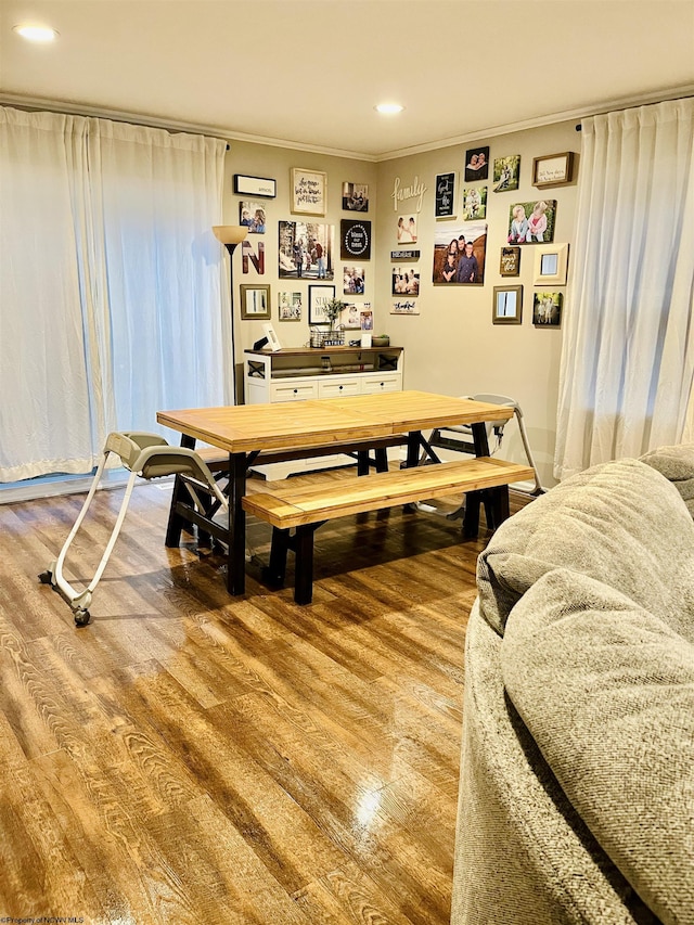 dining space featuring hardwood / wood-style flooring and crown molding