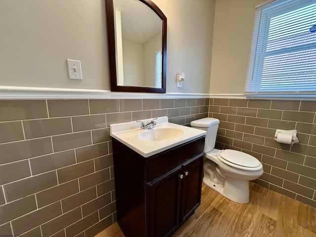 bathroom with vanity, hardwood / wood-style floors, tile walls, and toilet