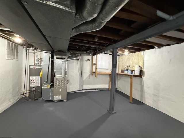 basement featuring gas water heater and heating unit