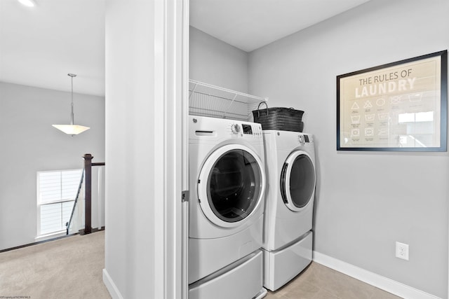 laundry area with washing machine and clothes dryer and light colored carpet