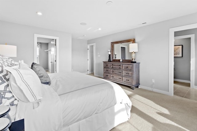 bedroom featuring a spacious closet and light colored carpet