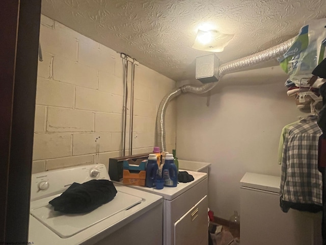 laundry room with washer and dryer and a textured ceiling